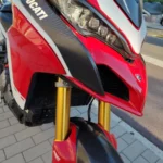 Gros plan sur le carénage avant rouge et blanc Ducati Corse avec finitions carbone sur une Multistrada 1260 Pikes Peak.