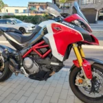 Vue latérale droite d'une moto Ducati Multistrada 1260 Pikes Peak d'occasion aux couleurs Ducati Corse avec cadre treillis rouge.