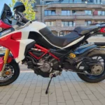 Profil latéral gauche d'une Ducati Multistrada 1260 Pikes Peak garée, montrant la chaîne et le mono-bras oscillant.