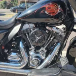 Zoom sur la valise rigide latérale droite noire d'une Harley-Davidson Street Glide avec détails de pinstriping et feux arrière chromés.