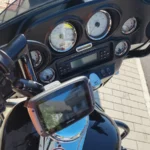 Vue du poste de pilotage d'une Harley-Davidson Street Glide 96ci équipée de cadrans analogiques à fond blanc, d'un système audio Harley-Davidson et d'un GPS TomTom au guidon.